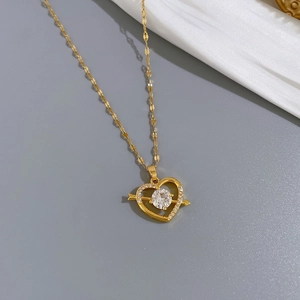 Close-up of titanium steel gold heart necklace with crystals on white silk background