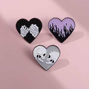 Macro detail of heart enamel pins featuring gothic skull and purple flame designs