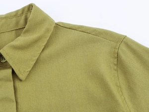 Detail view of mustard yellow linen shirt neckline with reinforced stitching and buttons