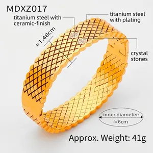 Detail showing 14.8mm wide gold titanium steel bangle with grid texture and crystals