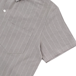 Detail of the stitching on a grey striped linen shirt with a front chest pocket