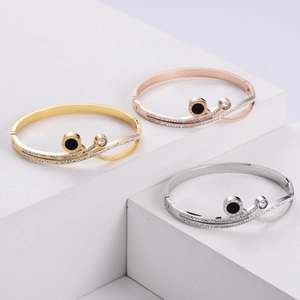 Trois bracelets en acier titane avec strass incrustés et chiffres romains