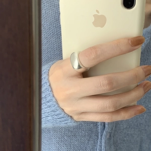 Close-up of minimalist chunky silver ring with wide band worn on finger
