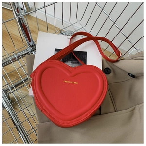 Dettaglio della borsa rossa a forma di cuore su un cappotto in un carrello