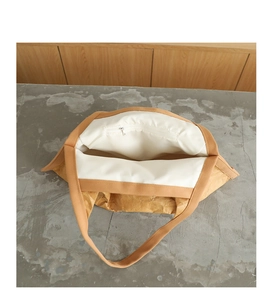 Detail view of the beige paper tote interior showing fabric lining and a zipper pocket