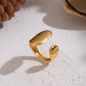 Polished gold geometric open ring minimalist adjustable jewelry on textured surface