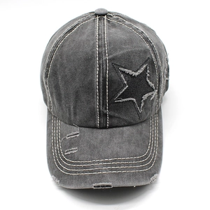 Détails d'une casquette de baseball en jean gris foncé délavé avec patch étoile et usure