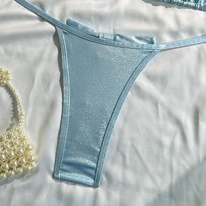 Detailed macro view of light blue sequined bikini bottom with shimmering metallic texture