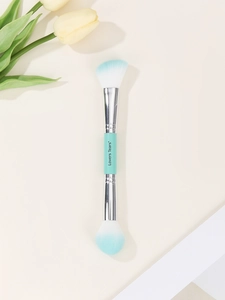 Detailed macro view of dual-ended makeup brush with teal handles and synthetic bristles