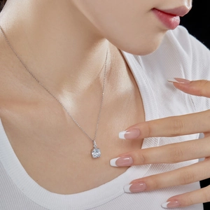 Close-up of a pendant necklace featuring a square light blue gemstone on a silver chain