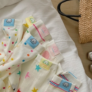 Colorful striped and polka dot cotton crew socks with puppy label on white bedding
