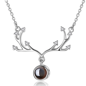 Macro detail of silver antler pendant featuring a centered circular projection stone