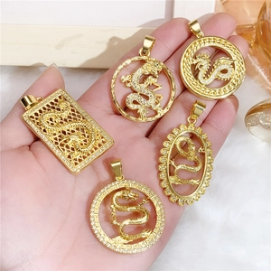 Close-up of gold-plated dragon pendants with white cubic zirconia in various hollow shapes