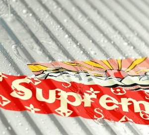 Makroaufnahme von wasserfesten Graffiti-Stickern auf Metallkoffer mit klaren Wassertropfen