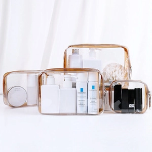 Detailed set of four transparent PVC travel makeup bags with brown piping and zippers