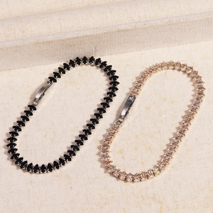 Detail of marquette-cut cubic zirconia tennis bracelets in black and champagne gold colors
