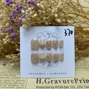 Detailed view of handmade baroque pearl press-on nails set with glitter and gold trim
