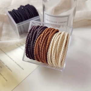 High elasticity striped hair ties in neutral colors stored in a minimalist acrylic box