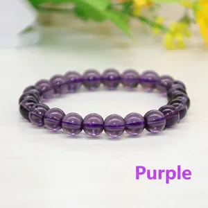Vue détaillée du bracelet en perles de cristal violet avec pierres rondes sur bois