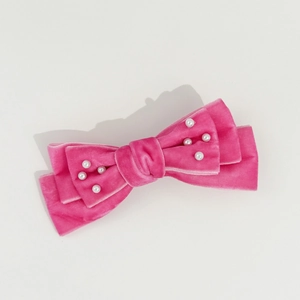 Close-up of pink velvet bow hair clip with faux pearl accents in multi-layer design