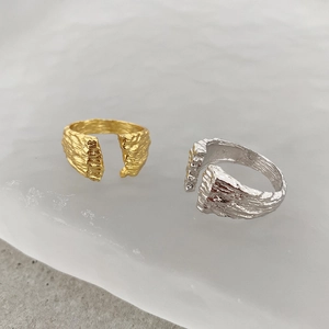 Detail shot of open rings showing unique rock texture in gold and silver finishes