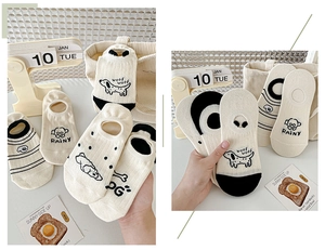 Detailed view of cream-colored low-cut socks with cute cartoon puppy patterns and stripes
