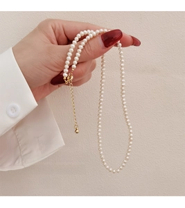 Detailed close-up of delicate natural pearl necklace with golden extension chain
