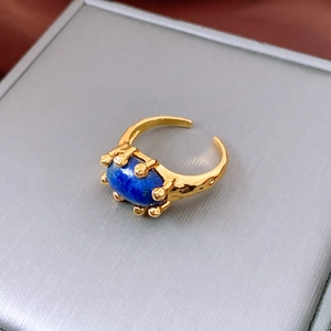 Detailed close-up of 18K gold plated ring with blue oval lapis stone and hammered texture