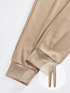 Detailed macro view of khaki waffle knit fabric and drawstring waistband on joggers