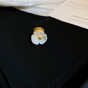 Close-up of white camellia flower earring with golden core and premium metal finish