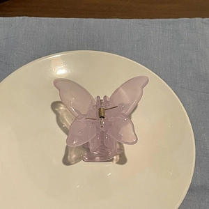 Detailed macro of a light purple translucent butterfly hair claw clip with resin texture