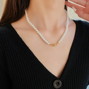 Close-up of vintage pearl necklace with a minimalist gold magnetic clasp on model neck
