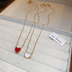 Collier minimaliste en or avec pendentifs cœurs rouge et blanc dans un écrin