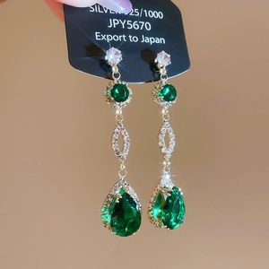 Macro shot of 925 silver emerald teardrop earrings with sparkling cubic zirconia accents