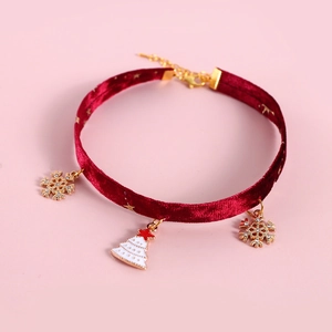 Close-up of wine red velvet pet collar with gold snowflake and Christmas tree pendants