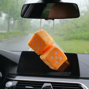 Orange plush car dice hanging on rearview mirror with purple heart embroidery detail