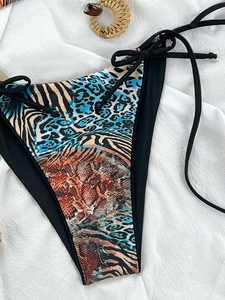 Detail of leopard and zebra print bikini bottom with adjustable side ties and woven ring