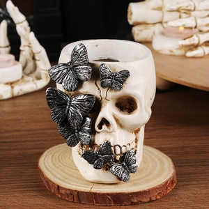 Gothic skull ornament with silver butterflies on a wooden base for Halloween decor