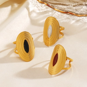 Three gold oval rings with black, white, and red drip oil inserts on white silk fabric