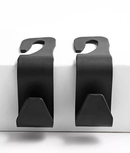 Detailed view of two matte black car headrest hooks on a clean studio background