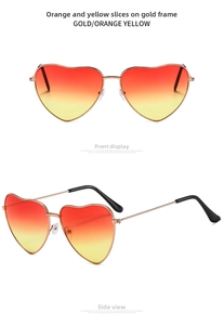 Detail view of heart-shaped sunglasses with gold metal frames and orange gradient lenses