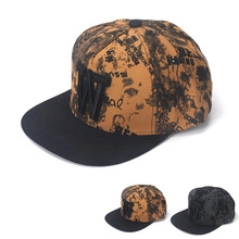 Detail of brown graffiti baseball cap with black embroidered W and canvas texture