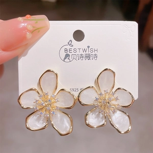 Macro detail of white five-petal flower earring with gold edges and S925 silver needle