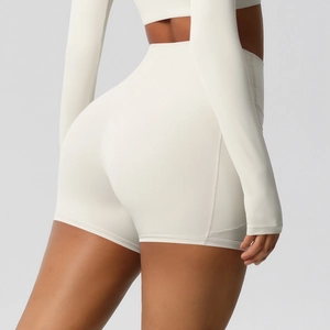 Close-up of peach-line lifting seams on off-white high-waist yoga shorts and top