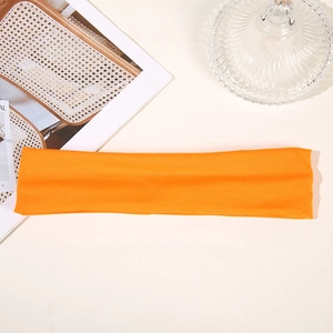 Detailed view of an orange sweat-wicking athletic headband for running and yoga