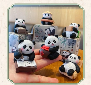 Hand holding cute resin panda figurines with traditional Chinese ink wash packaging