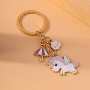 Cartoon unicorn keychain with purple umbrella and smiling cloud charms on a peach background