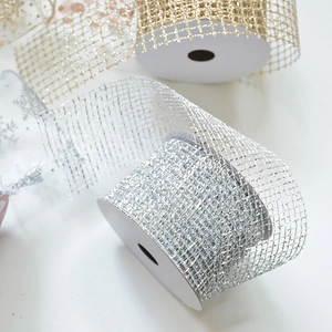 Macro view of gold and silver glitter mesh ribbons with snowflake patterns for gift decor