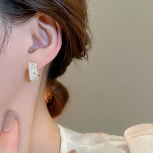 Close-up of elegant crown lace pearl earrings on model with French vintage design