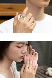 Detailed view of Thai silver puzzle rings on hands in silver and gold contrast